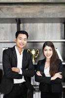 lachende jonge zakenman en zakenvrouw dragen pak gekruiste arm op moderne kantoorachtergrond, zakelijk succesvol foto