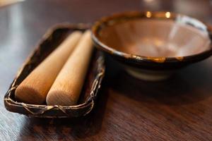 Japanse sesam slijpkom en houten stok op houten tafel. foto