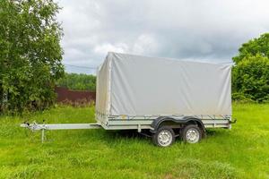 een autoaanhanger met twee assen staat geparkeerd. foto