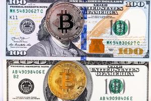 platina en gouden bitcoin op de achtergrond van honderd-dollarbiljetten foto