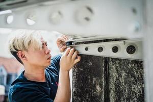 een professionele elektricien man repareert rubberen schokdemper trillingsisolatoren voor airconditioners om laagfrequent geluid veroorzaakt door trillingen te verminderen foto