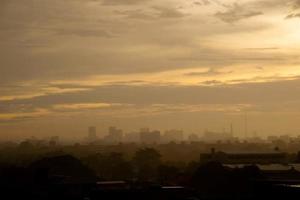 achtergrond zware regen vallen uit regenseizoen hemel, boom en gebouw silhouet, tropisch thailand. foto