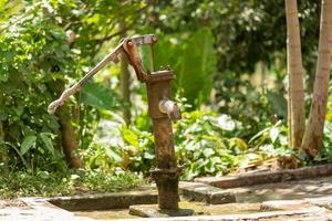 oude hand waterpomp in dorp foto