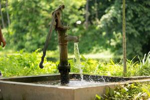 oude hand waterpomp in dorp foto