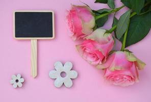 roze achtergrond en rozen, met lege zwarte krijtbord label