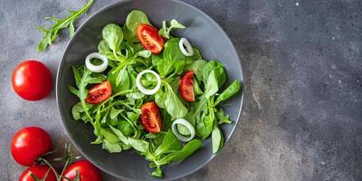 salade groente tomaat, ui, sla mix, mache groen vers gezond maaltijd eten snack dieet op tafel kopieer ruimte voedsel achtergrond rustieke bovenaanzicht foto
