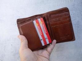 Surabaya, Jawa Timur, Indonesië, 2022 - een man houdt een leren portemonnee vast met Indonesische 'sim a' en 'sim c' kaarten foto