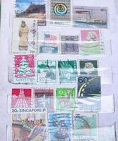 sidoarjo, jawa timur, indonesia, 2022 - close-up foto's van old-school postzegels uit diverse landen verpakt in boeken foto
