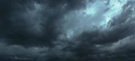 de donkere lucht met zware wolken die samenkomen en een hevige storm voor de regen. slecht weer hemel. foto