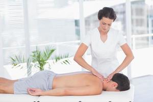 fysiotherapeut die nekmassage doet aan haar patiënt foto