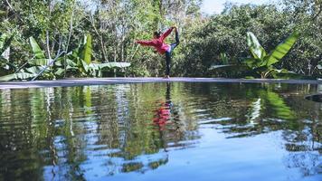 jong meisje permanent ontspannen lichaam, yoga oefening. warmwaterbronnen in nationaal park, reizen in de natuur met warmwaterbronnen, ontspannen en sporten bij het zwembad. foto