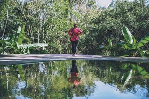 jong meisje permanent ontspannen lichaam, yoga oefening. warmwaterbronnen in nationaal park, reizen in de natuur met warmwaterbronnen, ontspannen en sporten bij het zwembad. foto