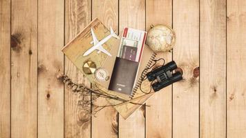 bovenaanzicht van reisaccessoires essentiële vakantieartikelen en verschillende objecten op houten achtergrond. reisconcept achtergrond, bereid je voor op reizen foto