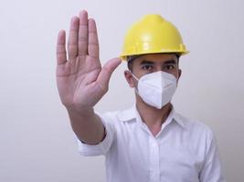 Aziatische industriële arbeiders dragen gele helmen, dragen beschermende maskers voor hun gezondheid foto