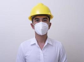 Aziatische industriële arbeiders dragen gele helmen, dragen beschermende maskers voor hun gezondheid foto