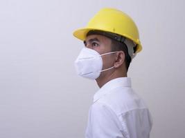 Aziatische industriële arbeiders dragen gele helmen, dragen beschermende maskers voor hun gezondheid foto