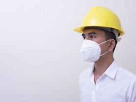 Aziatische industriële arbeiders dragen gele helmen, dragen beschermende maskers voor hun gezondheid foto