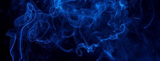 conceptueel beeld van blauwe kleur rook geïsoleerd op donkere zwarte achtergrond, halloween element ontwerpconcept. foto