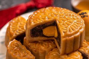 smakelijk gebakken eidooiergebak maancake voor mid-herfstfestival op zwarte leisteen donkere achtergrond. Chinees feestelijk voedselconcept, close-up, kopieer ruimte. foto