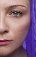 half gezicht van jong volwassen meisje met paarse foulard foto