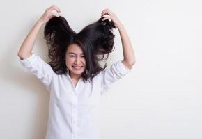 portret van een jonge aziatische vrouw die staat en glimlacht foto