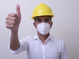 Aziatische industriële arbeiders dragen gele helmen, dragen beschermende maskers voor hun gezondheid foto