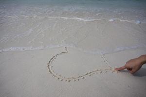 harten getekend op het zand van een strand foto
