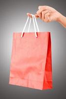 vrouwelijke hand met rode tas - winkel- en vakantieconcept foto