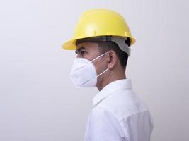 Aziatische industriële arbeiders dragen gele helmen, dragen beschermende maskers voor hun gezondheid foto