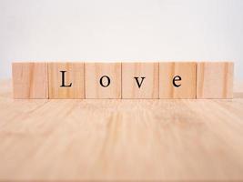 woord liefde op houten kubussen met rood hart, close-up in de buurt van witte achtergrond valentijn concept foto