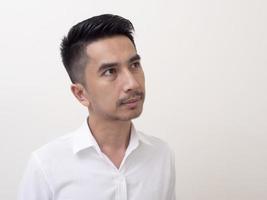 jonge aziatische man geïsoleerd op een witte achtergrond zijwaarts kijkend foto