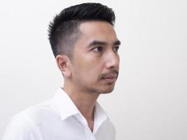 jonge aziatische man geïsoleerd op een witte achtergrond zijwaarts kijkend foto