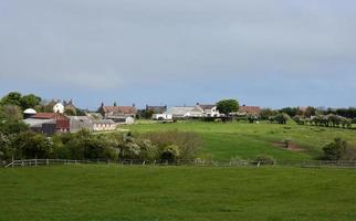 boerderij uit gebouwen in Noord-Engeland, omringd door velden foto