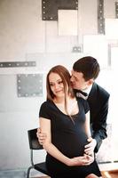 man zoenen en zijn zwangere vrouw omhelzen foto