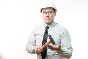 ingenieur in witte helm met in hand hamer