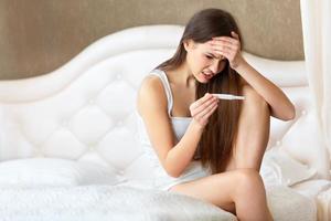 zwangerschaptest. bezorgd vrouw kijken naar een test foto