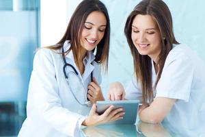 medisch en verpleegster op zoek naar iets op een digitale tablet foto