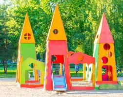 kinderachtige speeltuin in stadspark. schommel carrousel in park voor kinderen. kinderspeelplaats fel veelkleurig. moderne speeltuin voor kinderen in stadspark. kinderkleurstijl foto