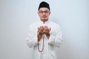 Aziatische moslim man bidt tot god in iftar-tijd, ramadan kareem vastenmaand concept foto
