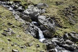 met rotsen omzoomde waterval die naar beneden stroomt foto