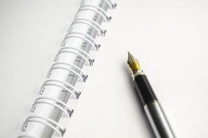 grijswaarden close-up shot van een vulpen bovenop een notebook foto
