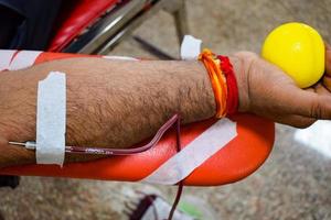 bloeddonor in bloeddonatiekamp gehouden met een springkussen in de hand in balaji-tempel, vivek vihar, delhi, india, afbeelding voor wereldbloeddonordag op 14 juni elk jaar, bloeddonatiekamp foto