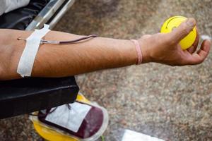 bloeddonor in bloeddonatiekamp gehouden met een springkussen in de hand in balaji-tempel, vivek vihar, delhi, india, afbeelding voor wereldbloeddonordag op 14 juni elk jaar, bloeddonatiekamp foto