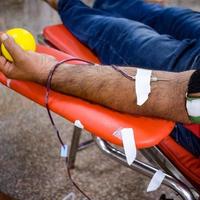 bloeddonor in bloeddonatiekamp gehouden met een springkussen in de hand in balaji-tempel, vivek vihar, delhi, india, afbeelding voor wereldbloeddonordag op 14 juni elk jaar, bloeddonatiekamp foto