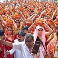 new delhi, india, 03 april 2022 - vrouwen met kalash op hoofd tijdens jagannath tempel mangal kalash yatra, indische hindoe toegewijden dragen aarden potten met heilig water met een kokosnoot erop foto