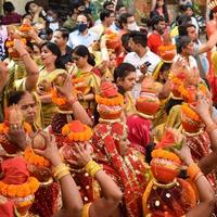 new delhi, india, 03 april 2022 - vrouwen met kalash op hoofd tijdens jagannath tempel mangal kalash yatra, indische hindoe toegewijden dragen aarden potten met heilig water met een kokosnoot erop foto