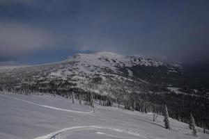 zonnige winterochtend in de bergen van sheregesh op de skipiste foto