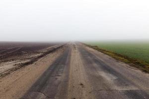 geasfalteerde weg, herfst en mist foto