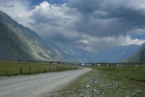 lint van de weg tussen de hellingen van de bergen op de uitgestrekte altai op een zomerdag foto