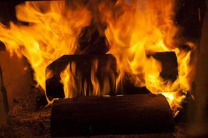 houtblokken verbranden in het vuur van een barbecue of kachel of open haard foto